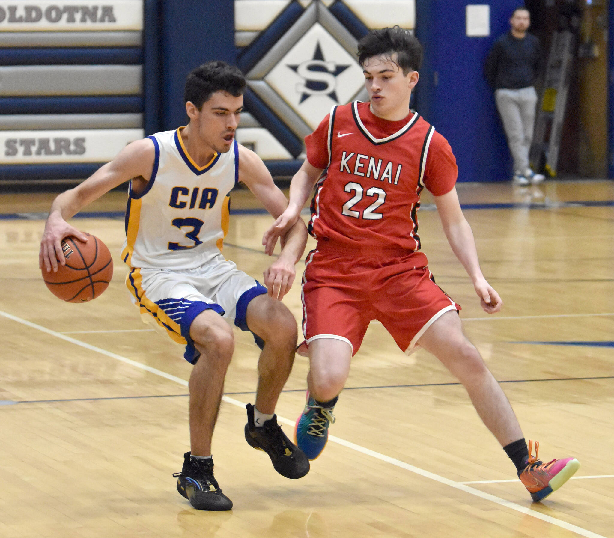 Cook Inlet Academy’s Ian McGarry dribbles against Kenai Central’s Ben Harris on Saturday, Jan. 25, 2025, at the Revolution Sport and Spine Therapy Al Howard Shootout at Soldotna High School in Soldotna, Alaska. (Photo by Jeff Helminiak/Peninsula Clarion)