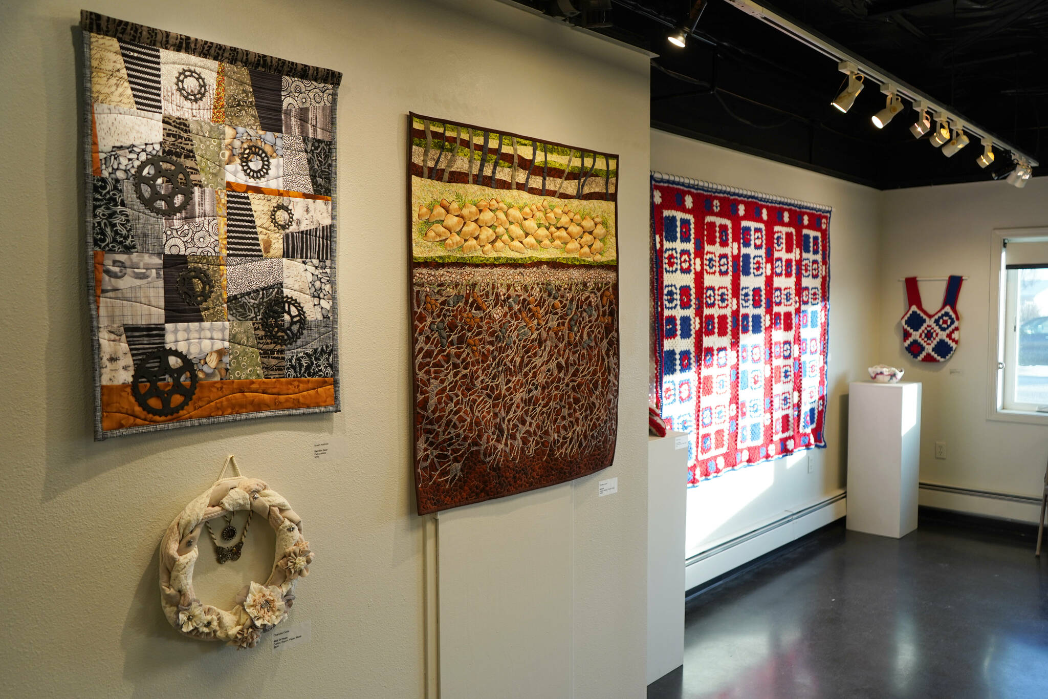 Artwork by Susan Nabholz, Charlotte Coots and Chelline Larsen is displayed as part of “Fiber” at the Kenai Art Center in Kenai, Alaska, on Wednesday, Feb. 5, 2025. (Jake Dye/Peninsula Clarion)