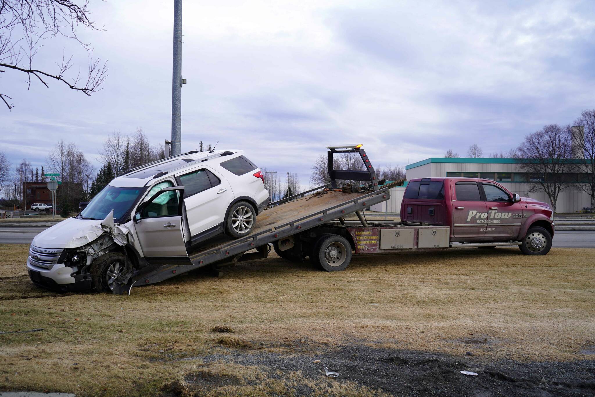A 2015 Ford Explorer that police say was stolen from the Kenai Chamber of Commerce and Visitor Center before crashing into a tree near Wells Fargo Bank is loaded onto a tow truck in Kenai, Alaska, on Tuesday, Feb. 18, 2025. (Jake Dye/Peninsula Clarion)