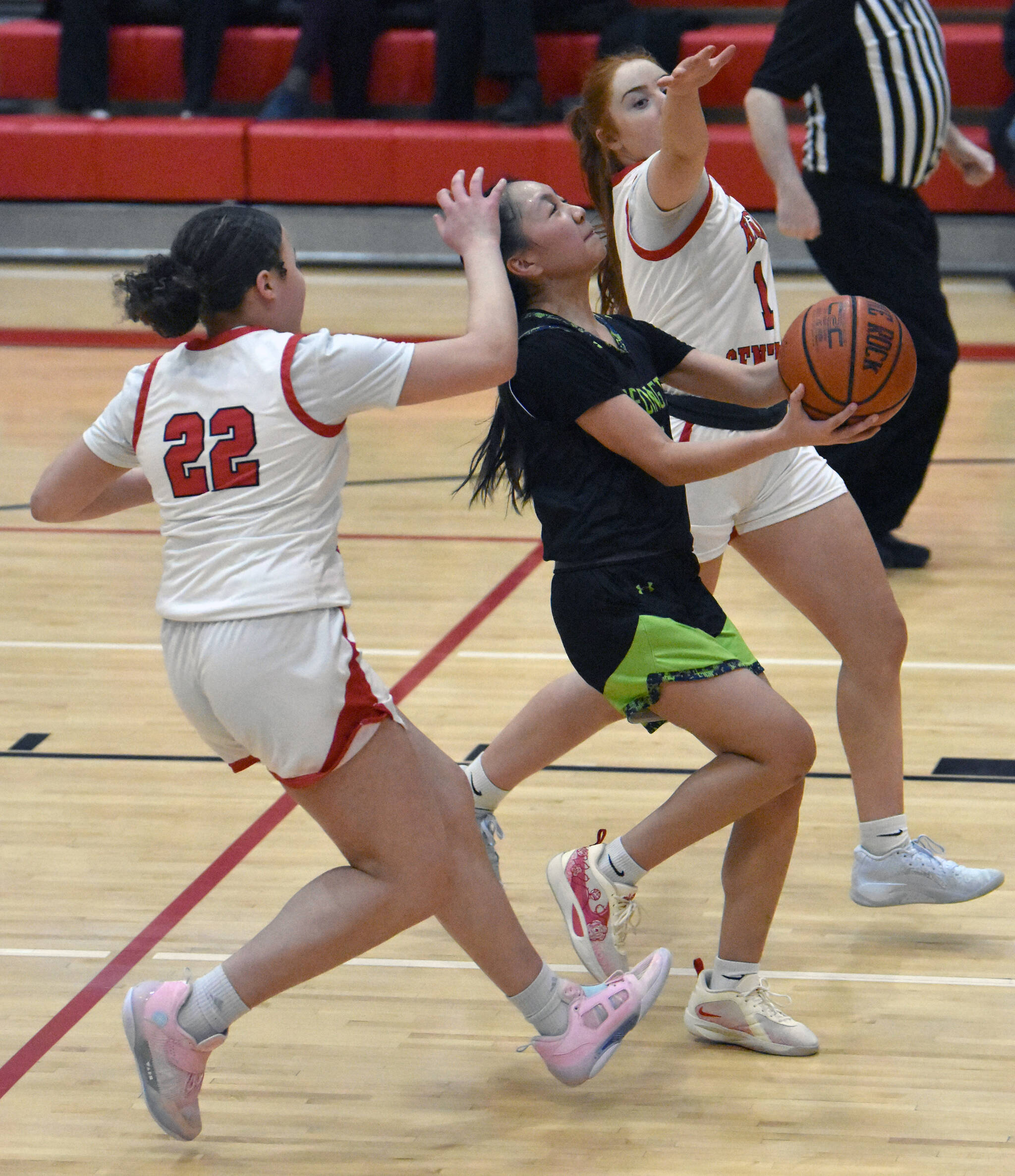 Redington’s Abi Dagomos drives to the basket against Kenai Central’s Bryleigh Williams and Savannah Hershberger on Thursday, February 27, 2025, at Kenai Central High School in Kenai, Alaska. (Photo by Jeff Helminiak/Peninsula Clarion)