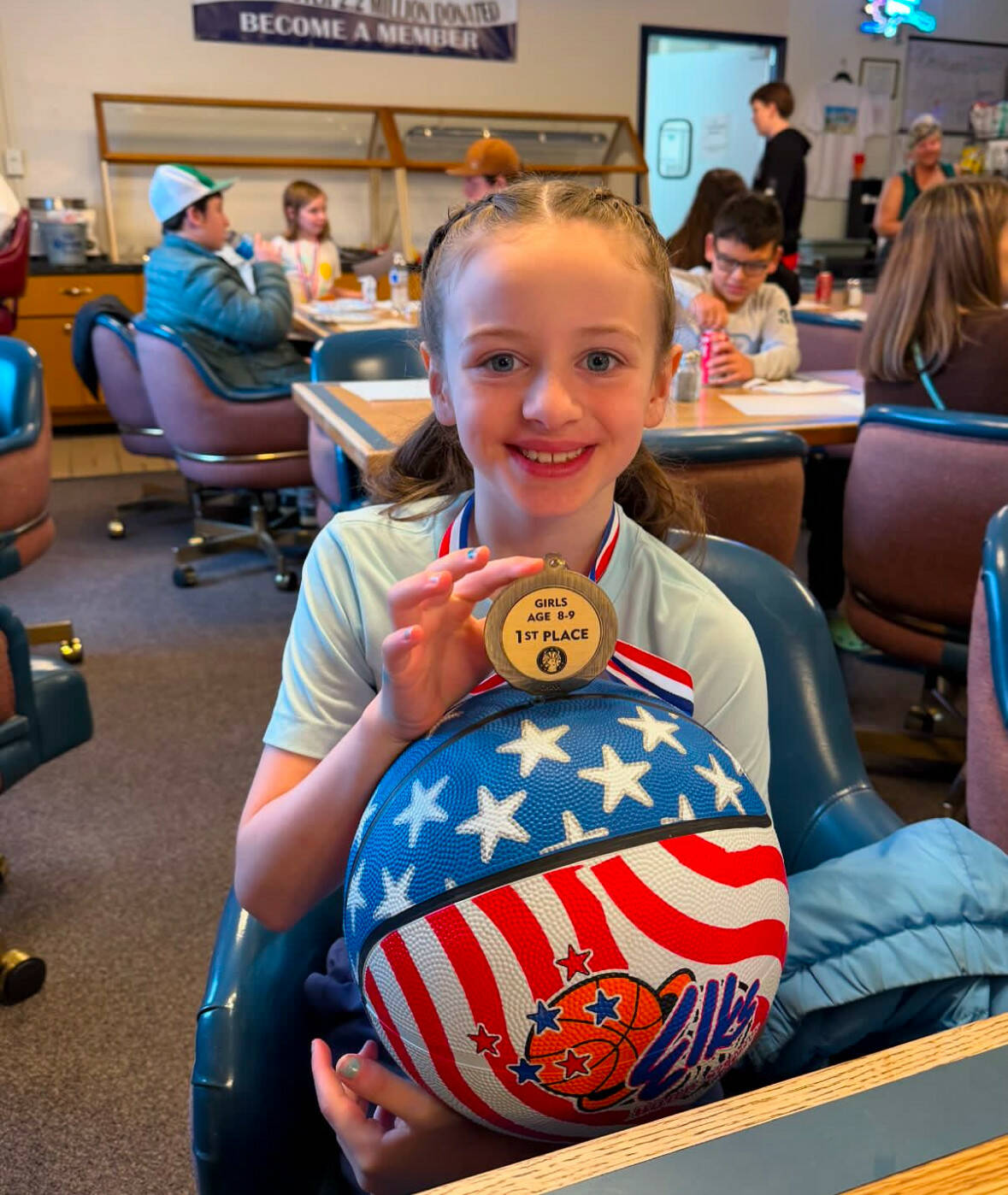 Laila Taylor sits with her first-place medal from the Kenai Elks Lodge Hoop Shoot at the Kenai Elks Lodge in Kenai, Alaska, on Saturday, Nov. 16, 2024. (Photo provided by Amber Rouswell)
