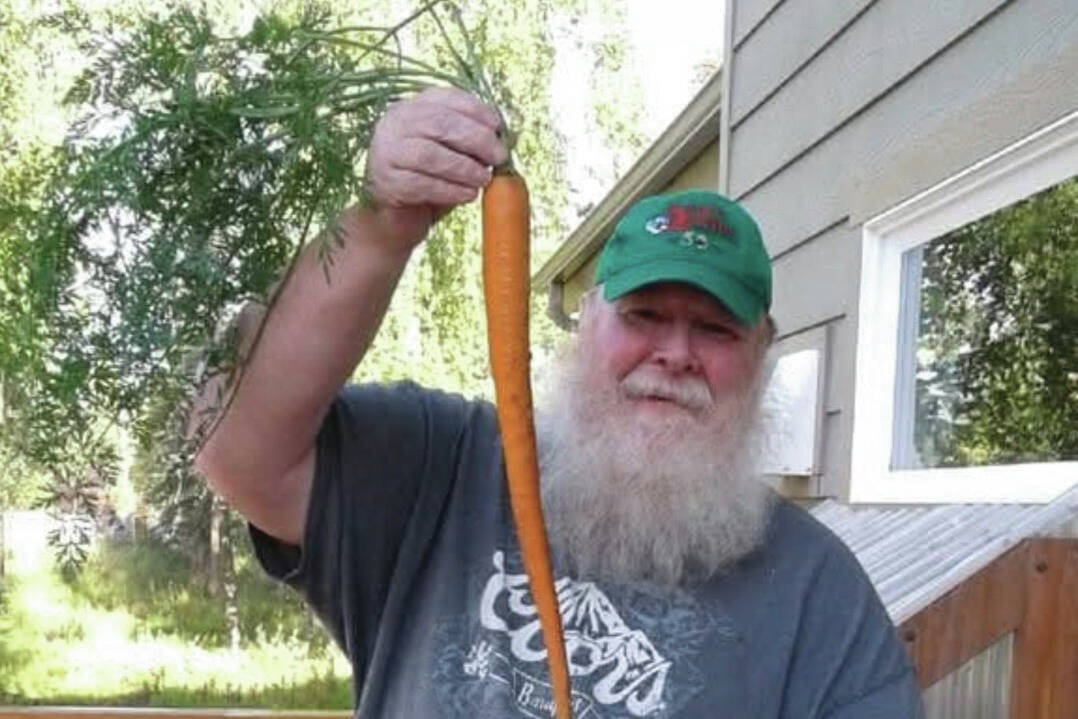 Larry Opperman, host of “Growing a Greener Kenai” radio show on local public radio station KDLL 91.9 FM, shows off a carrot. (Photo provided)