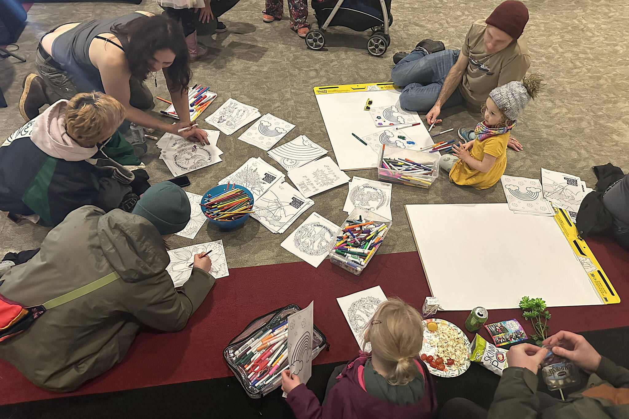 Children and adults color outlines of rainbows and other art during a Unity for the Queer Community event Sunday afternoon at Elizabeth Peratrovich Hall. (Mark Sabbatini / Juneau Empire)