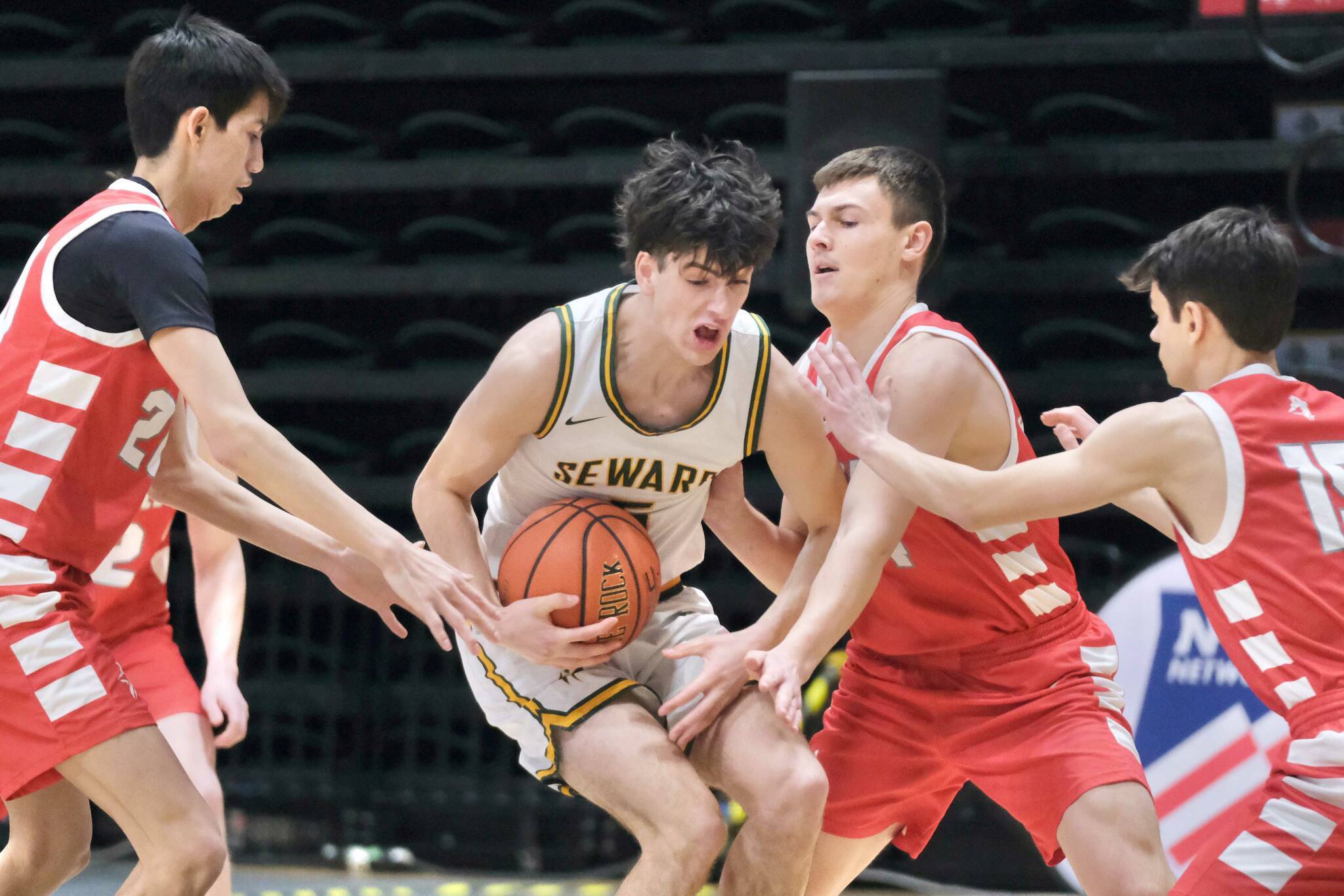 Seward's Van Shank protects the ball from Wrangell's Kyan Stead (20), Daniel Harrison and Lucas Schneider (15) during the Seahawks' 57-30 win over the Wolves in opening day action at the 2025 ASAA March Madness Alaska 2A State Basketball Championships on Thursday, March 13, 2025, in Anchorage's Alaska Airlines Center. (Klas Stolpe / Juneau Empire)