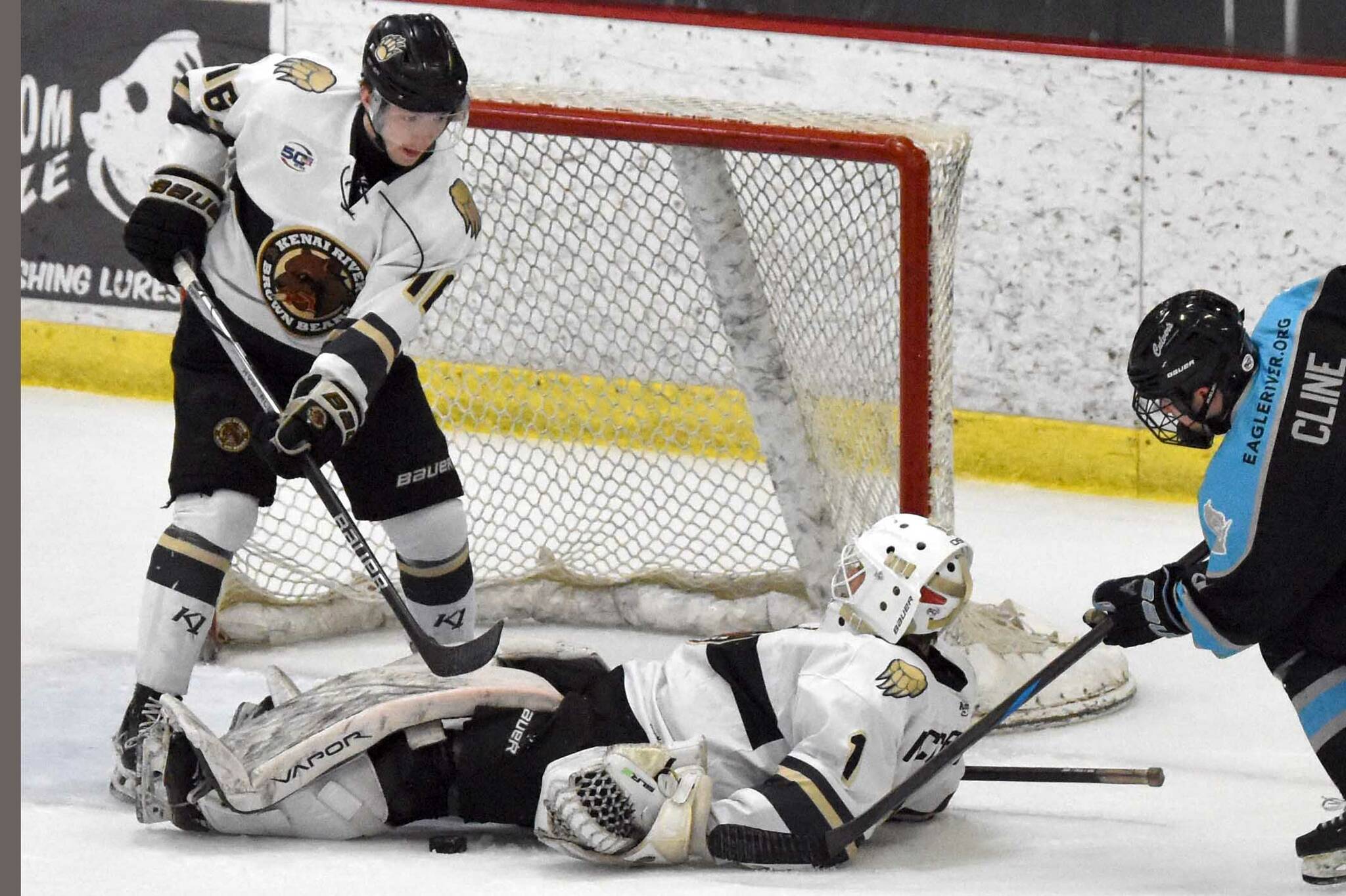 Kenai River Brown Bears goalie Mitchell Mccusker has the puck trapped under his body as Carter McCormick and Colten Nestler of the Brown Bears and Zachary Cline of the Wisconsin Windigo battle Saturday, March 22, 2025, at the Soldotna Regional Sports Complex in Soldotna, Alaska. (Photo by Jeff Helminiak/Peninsula Clarion)