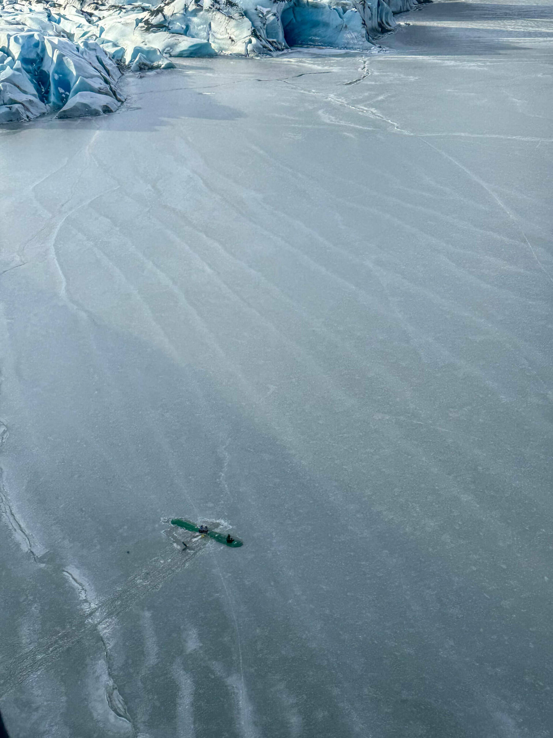 The three survivors of a Sunday afternoon plane crash are found atop the wing of their plane near Tustumena Lake in Kasilof, Alaska, on Monday, March 24, 2025. (Photo by Dale Eicher)