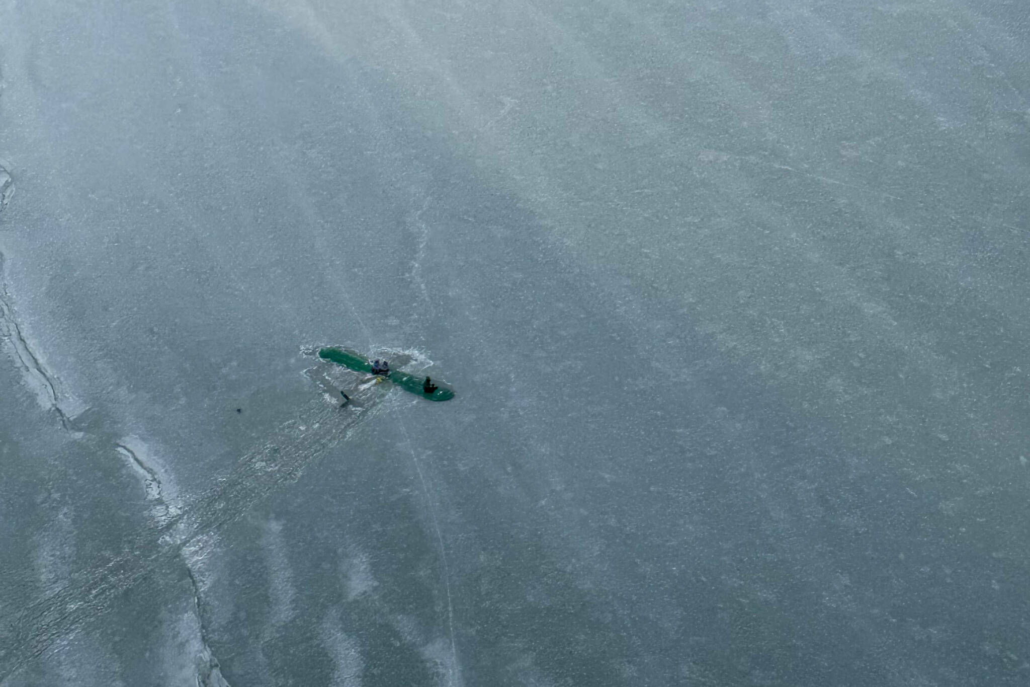The three survivors of a Sunday afternoon plane crash are found atop the wing of their plane near Tustumena Lake in Kasilof, Alaska, on Monday, March 24, 2025. (Photo by Dale Eicher)