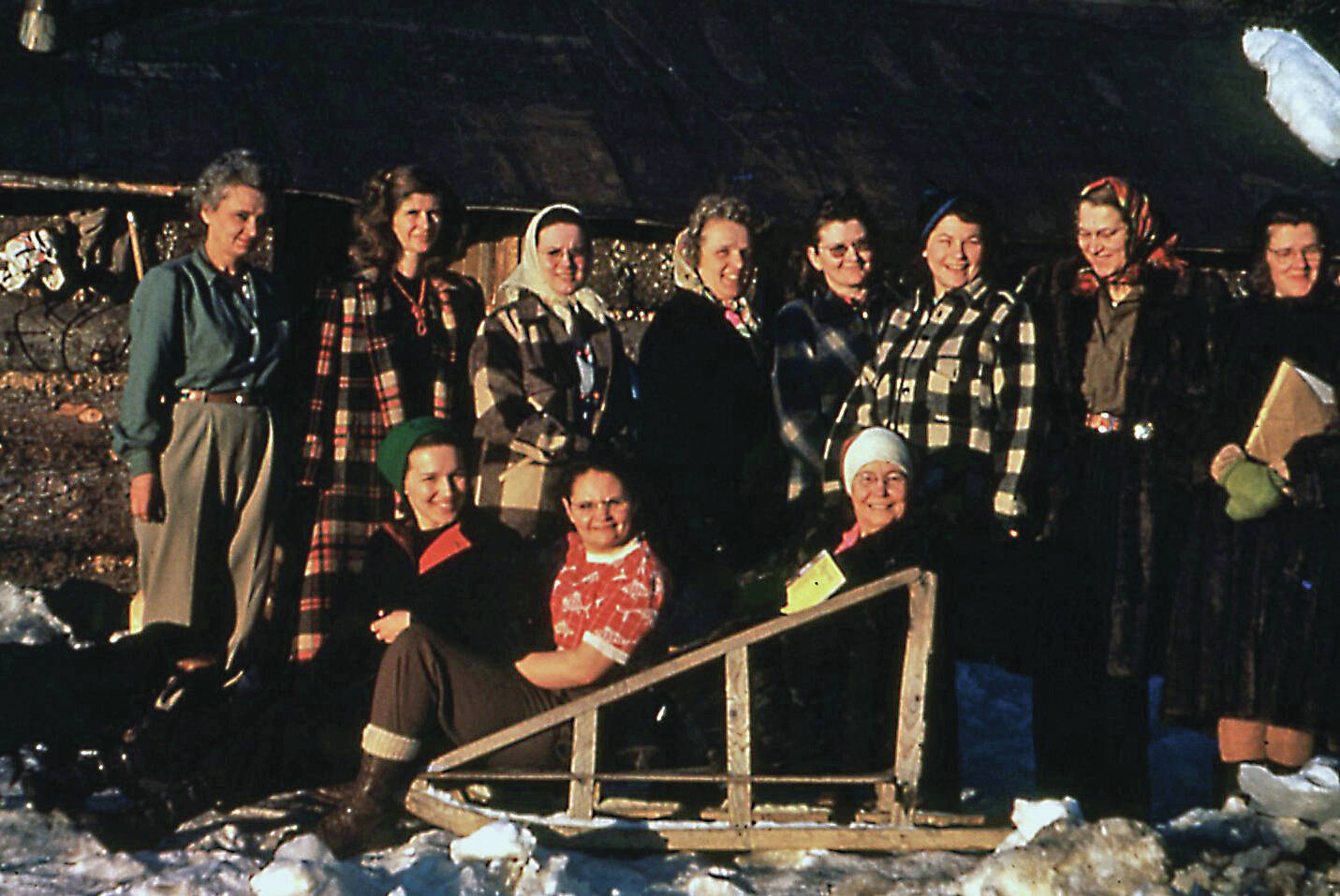 Photo courtesy of the Pratt Museum
During her brief time on the southern Kenai Peninsula, Dorothy Miller, wife of Cecil “Greasy” Miller, was a part of the Anchor Point Homemakers Club. Here, Dorothy (far left, standing) joins fellow area homemakers for a 1950 group shot. Sitting on the sled, in the red blouse, is Dorothy’s daughter, Evelyn, known as “Evie.”