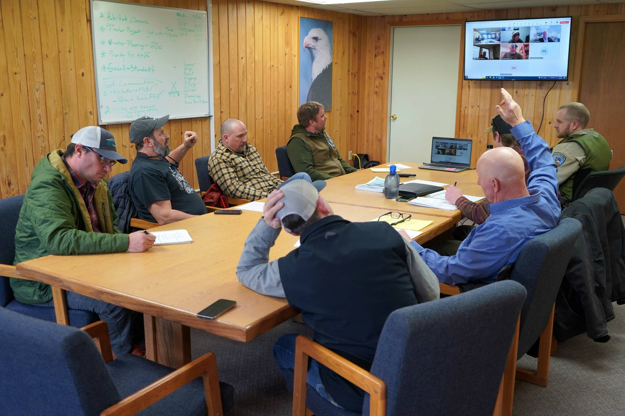 Monte Roberts, left, and Greg Brush, right, raise their hands during an emergency meeting of the Kenai River Special Management Area Advisory Board’s guide committee at the Kenai Peninsula Region Office of Alaska State Parks near Soldotna, Alaska, on Feb. 25, 2025. (Jake Dye/Peninsula Clarion)