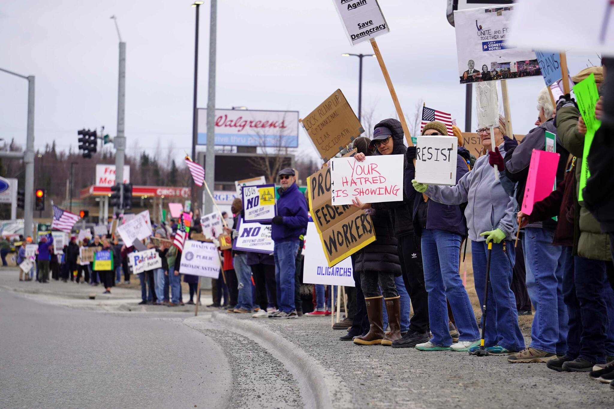 Protesters stand along the Sterling Highway in Soldotna, Alaska, participating in the “Remove, Reverse, Reclaim” protest organized by Many Voices and Kenai Peninsula Protests as part of the nationwide 50501 effort on Saturday, April 5, 2025. (Jake Dye/Peninsula Clarion)