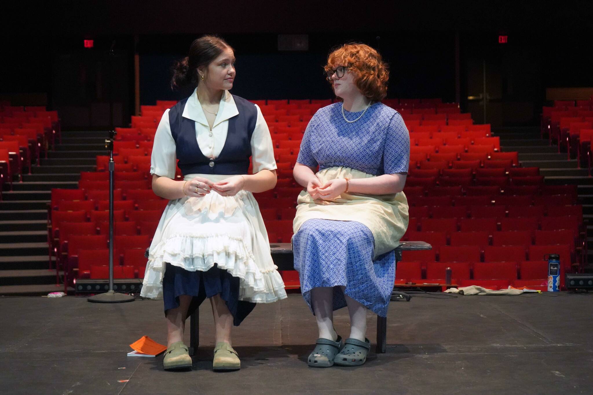 Hannah Burton and Ada Bon rehearse “Our Town” in the Soldotna High School Auditorium in Soldotna, Alaska, on Friday, April 18, 2025. (Jake Dye/Peninsula Clarion)