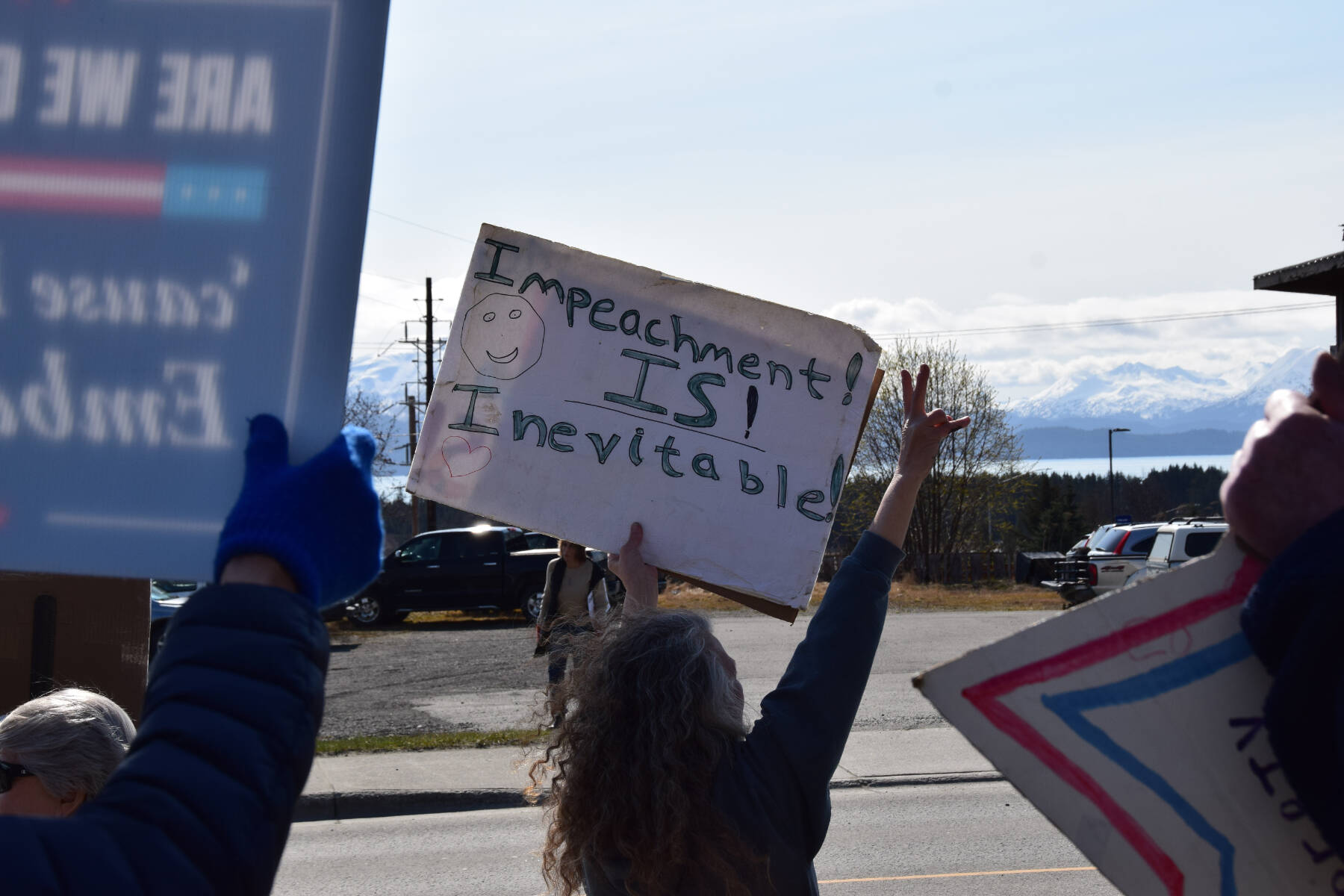 A protester throws a peace sign on Saturday, April 19 at WKFL Park during the “Sustained Resistance, Makes a Difference” Rally. (Chloe Pleznac/Homer News)