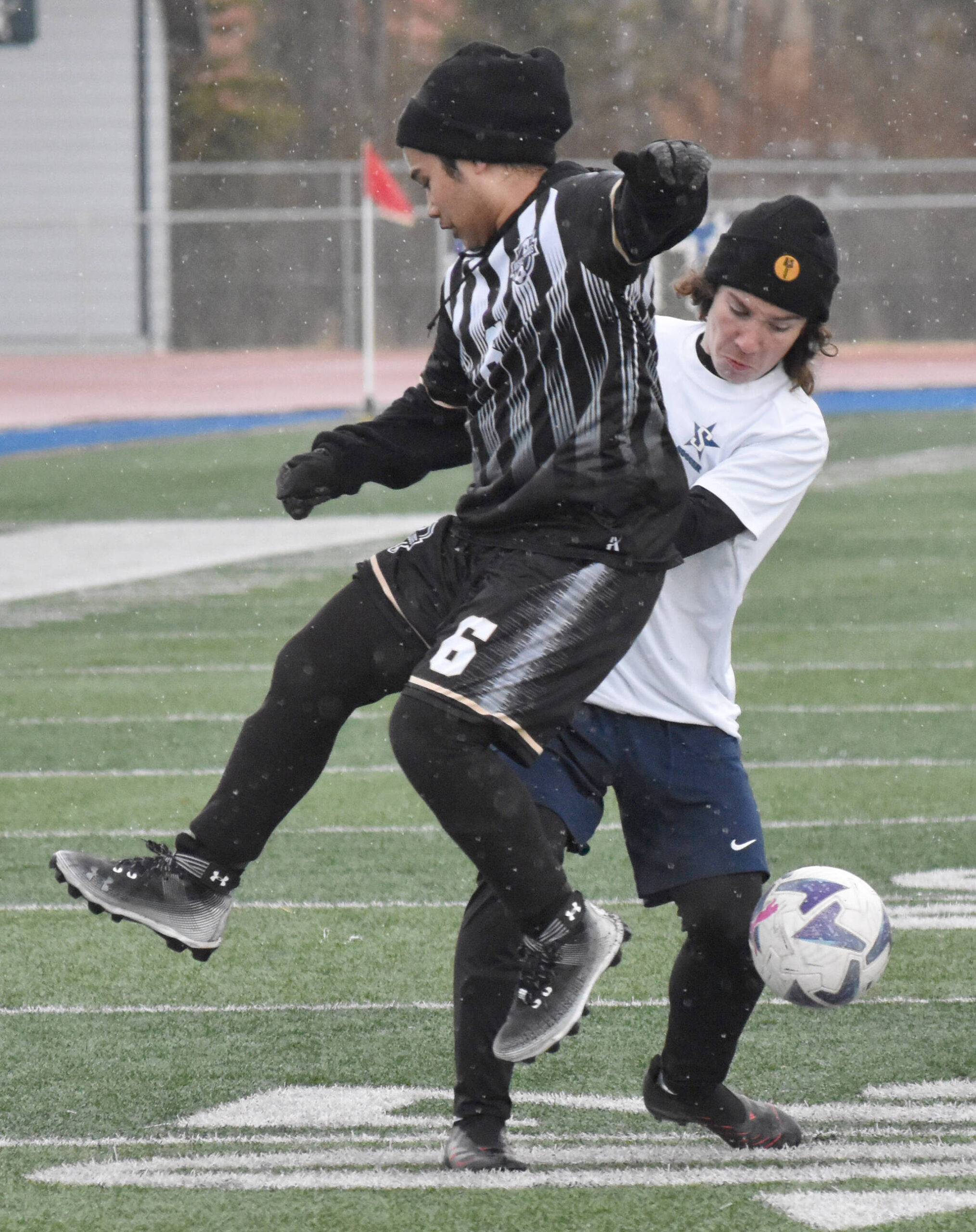Nikiski’s Frank Asibong and Soldotna’s Keegan Bross battle for the ball Tuesday, April 22, 2025, at Justin Maile Field at Soldotna High School in Soldotna, Alaska. (Photo by Jeff Helminiak/Peninsula Clarion)