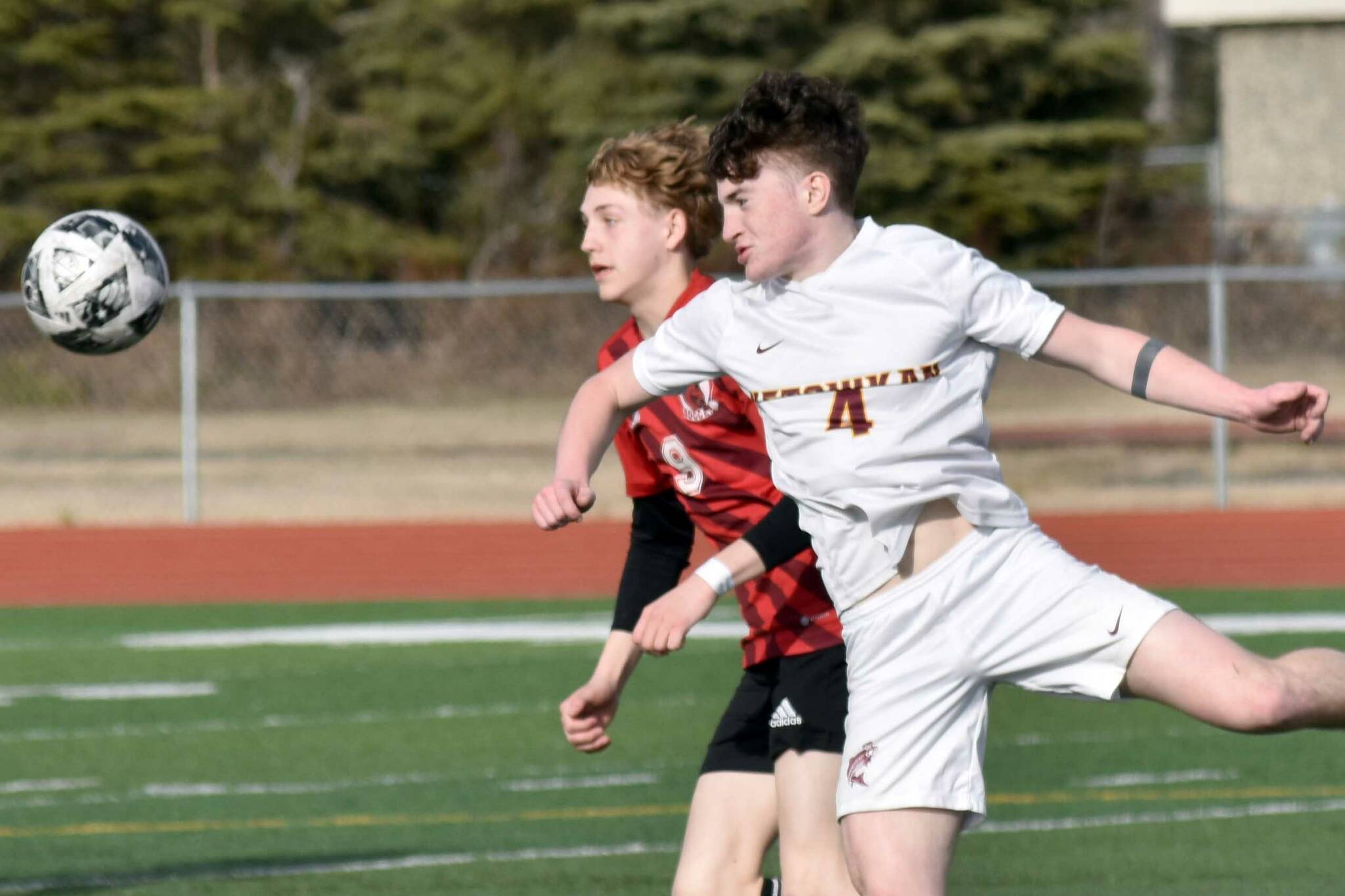 Kenai Central's Zane James and Ketchikan's Conor Pearson battle for the ball Wednesday, April 23, 2025, at Ed Hollier Field at Kenai Central High School in Kenai, Alaska. (Photo by Jeff Helminiak/Peninsula Clarion)