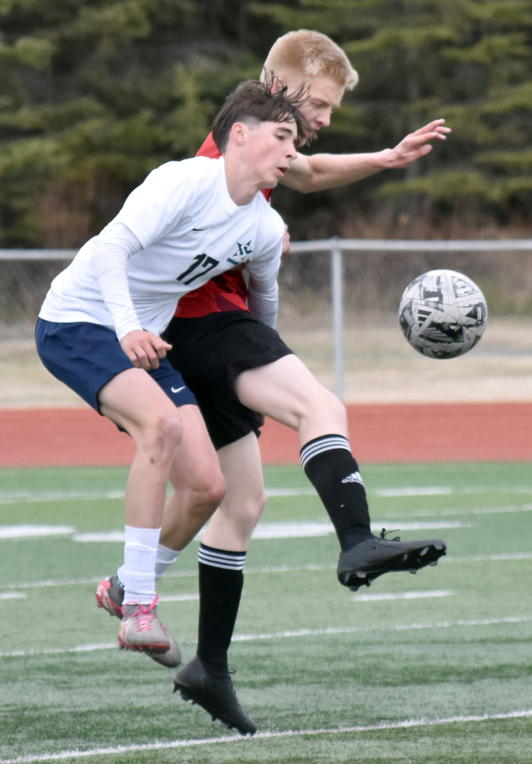 Soldotna’s Lane Hillyer and Kenai Central’s Dakota Wisnewski battle for the ball Saturday, April 26, 2025, at Ed Hollier Field at Kenai Central High School in Kenai, Alaska. (Photo by Jeff Helminiak/Peninsula Clarion)