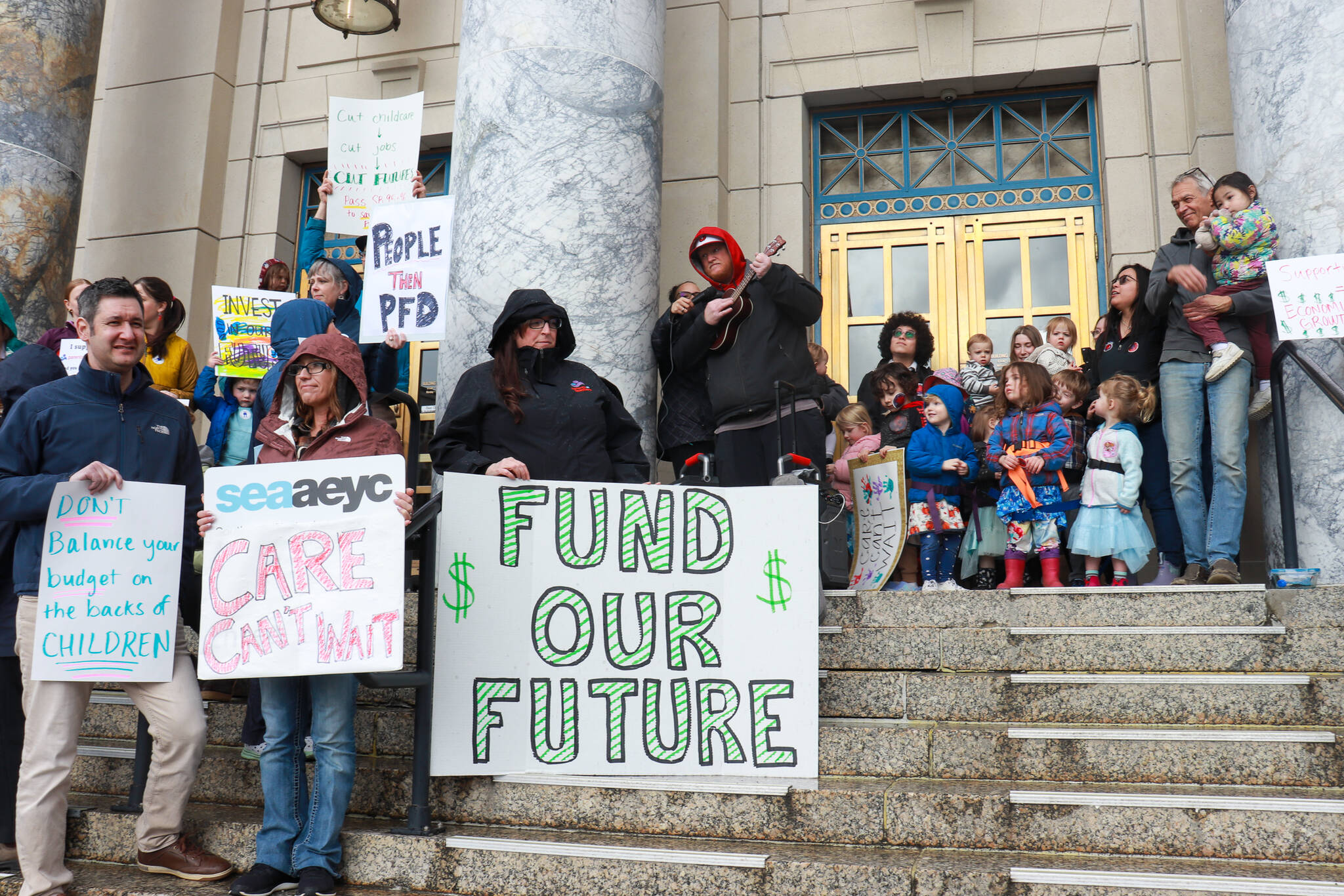 Geoff Kirsch and students from Sayéik Gastineau Community School sing during a rally for early education funding at the Alaska State Capitol on Tuesday, April 29, 2025. (Jasz Garrett / Juneau Empire)