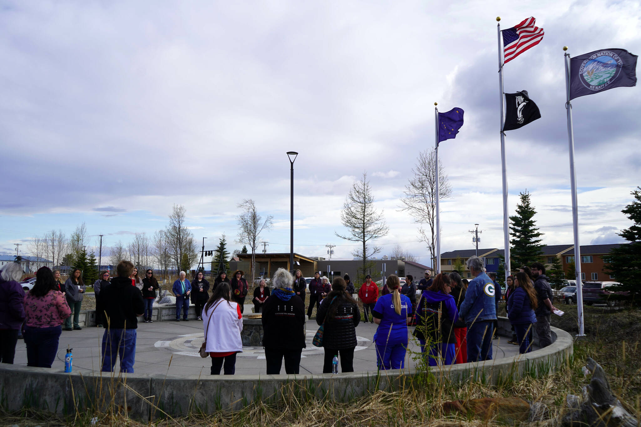 A group of people stand together to mark National Day of Awareness for Missing and Murdered Indigenous Women and Girls at the Raven Plaza, Ggugguyni T’uh, in front of the Dena’ina Wellness Center in Kenai, Alaska, on Monday, May 5, 2025. (Jake Dye/Peninsula Clarion)