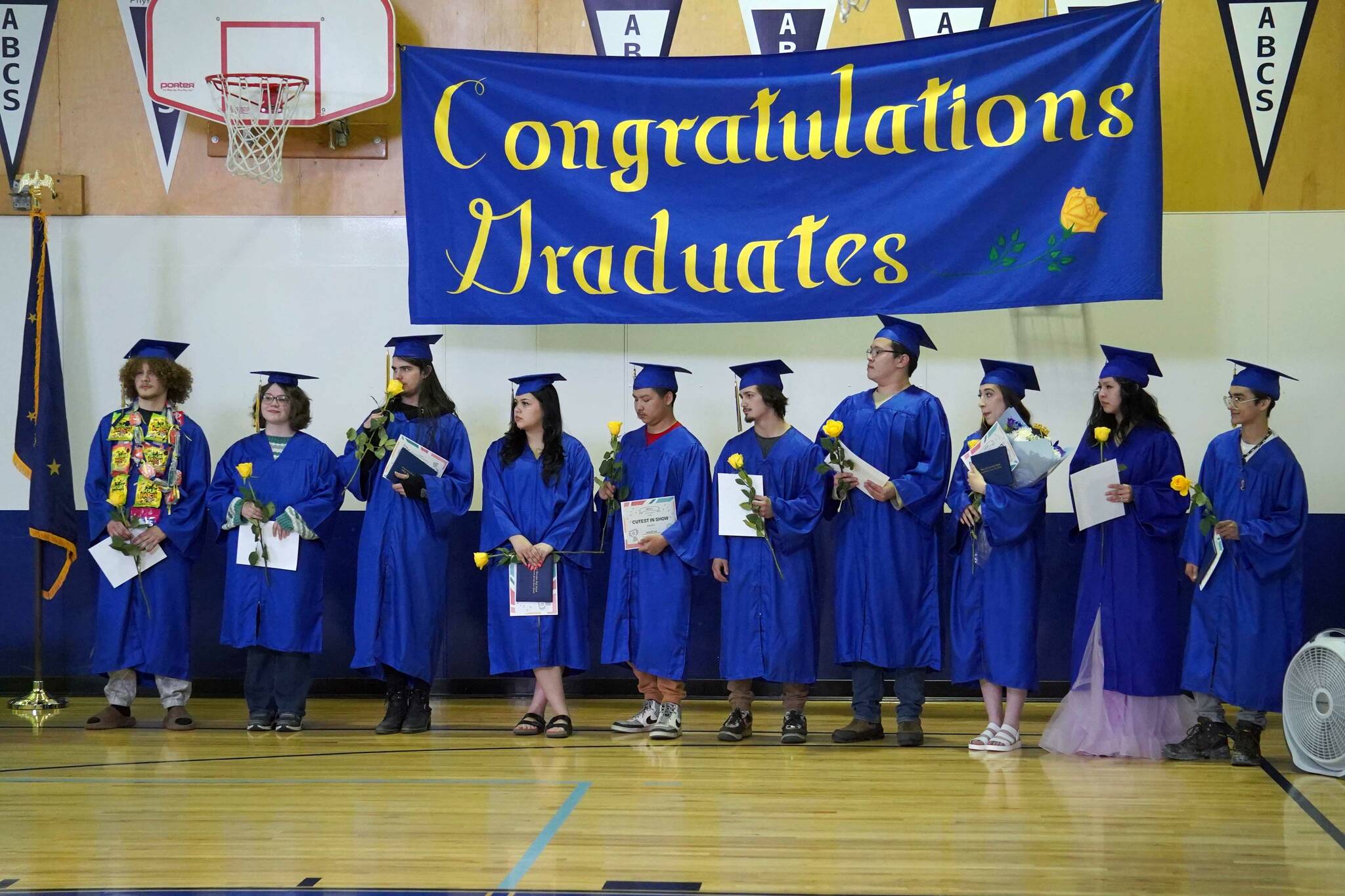 Kenai Alternative High School graduates stand with their diplomas at the conclusion of their commencement ceremony in the school’s gym in Kenai, Alaska, on Wednesday, May 22, 2025. (Jake Dye/Peninsula Clarion)