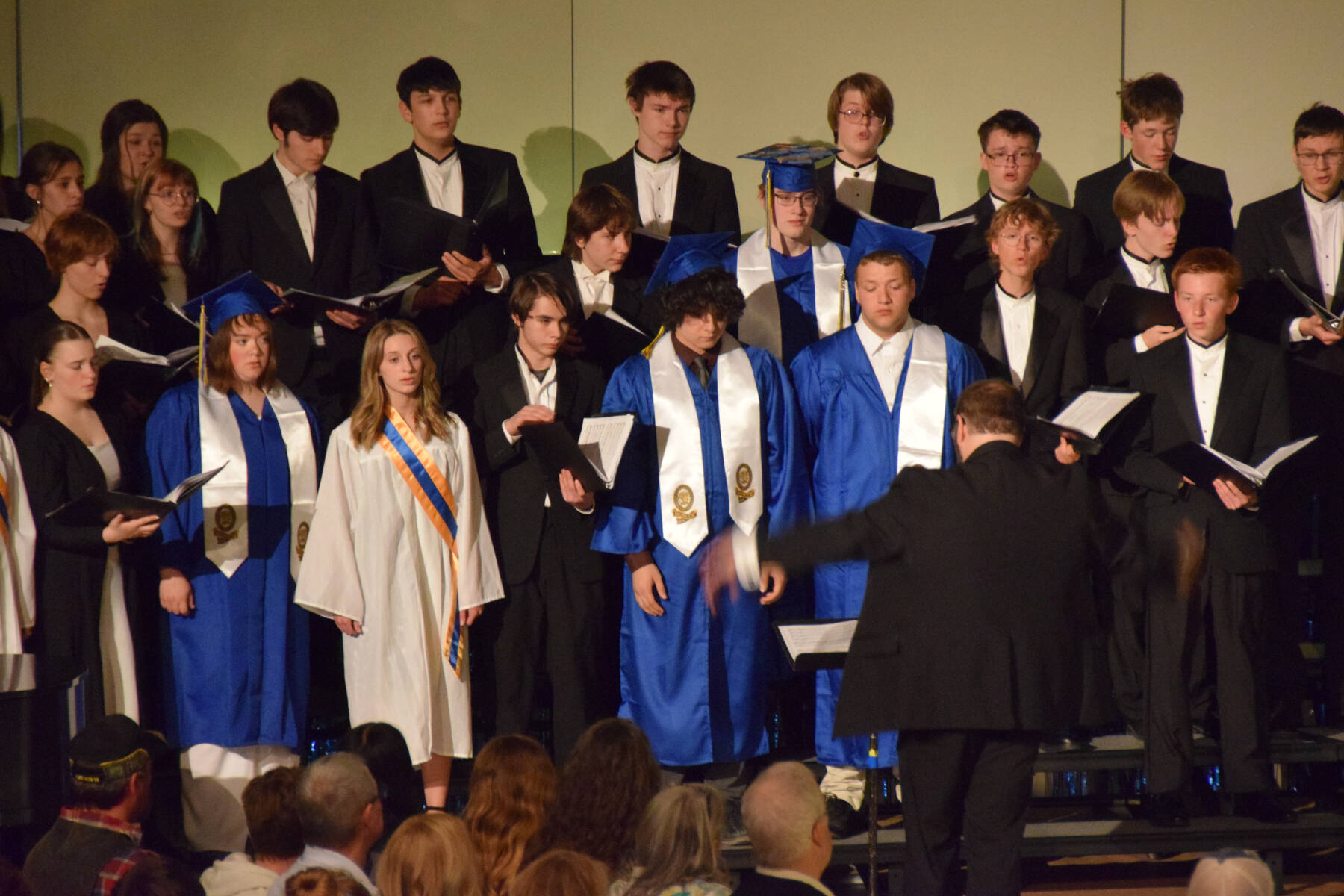 The Homer High School concert choir performs under the direction of Kyle Schneider during the 2025 Homer High School graduation ceremony on Wednesday, May 21, 2025, in the Alice Witte Gymnasium. (Chloe Pleznac/Homer News)