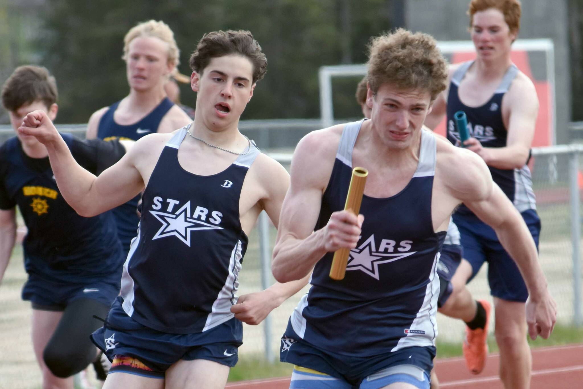 Soldotna's Tyce Escott hands to James Innes in the 400-meter relay Saturday, May 17, 2025, at the Kenai Peninsula Borough meet at Ed Hollier Field at Kenai Central High School in Kenai, Alaska. (Photo by Jeff Helminiak/Peninsula Clarion)