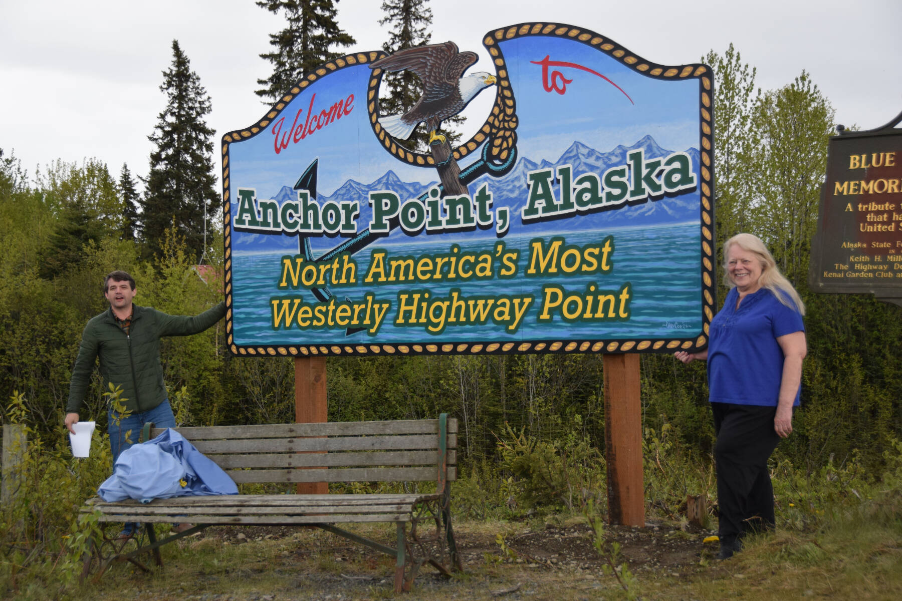 Anchor Point Chamber of Commerce President Dawson Slaughter (left) and Susie Myhill, co-owner of Anchor River Lodge and co-chair for the chamber’s sign committee, unveil the new “most westerly highway point” sign on Tuesday, May 27, 2025, in Anchor Point, Alaska. (Delcenia Cosman/Homer News)
