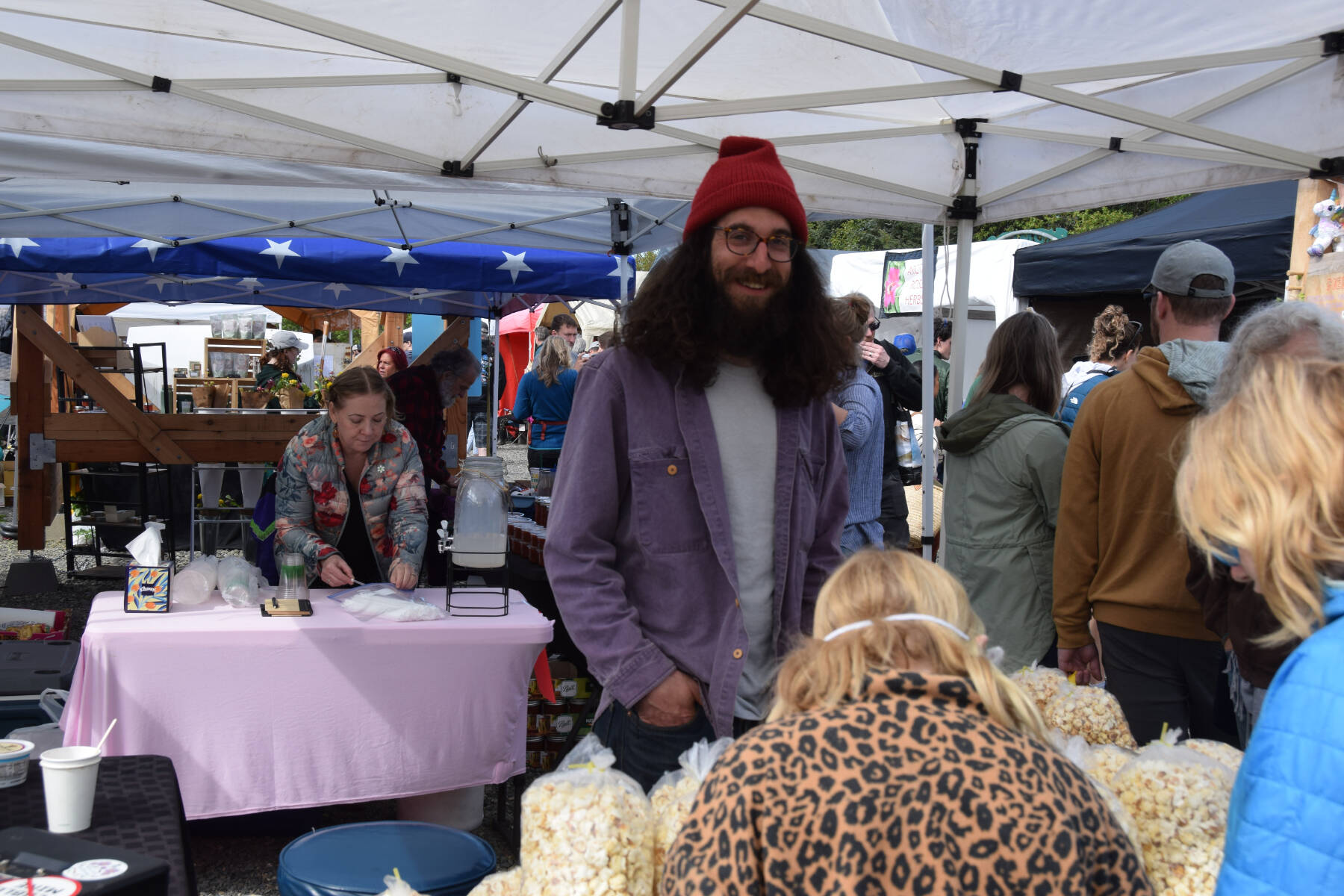Keon Mostofi smiles for a photo as interested, hungry customers consider his kettle corn selection on Saturday, May 24, 2025. (Chloe Pleznac/Homer News)