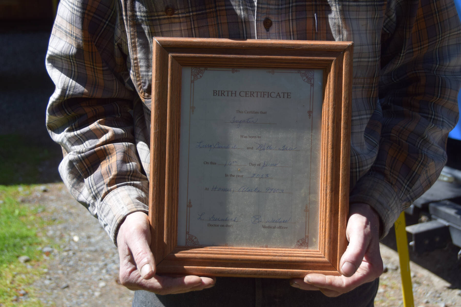 Larry Bernbeck holds a birth certificate he made for Tugster when beginning the build back in 2023 on Thursday, June 5, 2025 in Homer, Alaska. (Chloe Pleznac/Homer News). (Chloe Pleznac/Homer News)