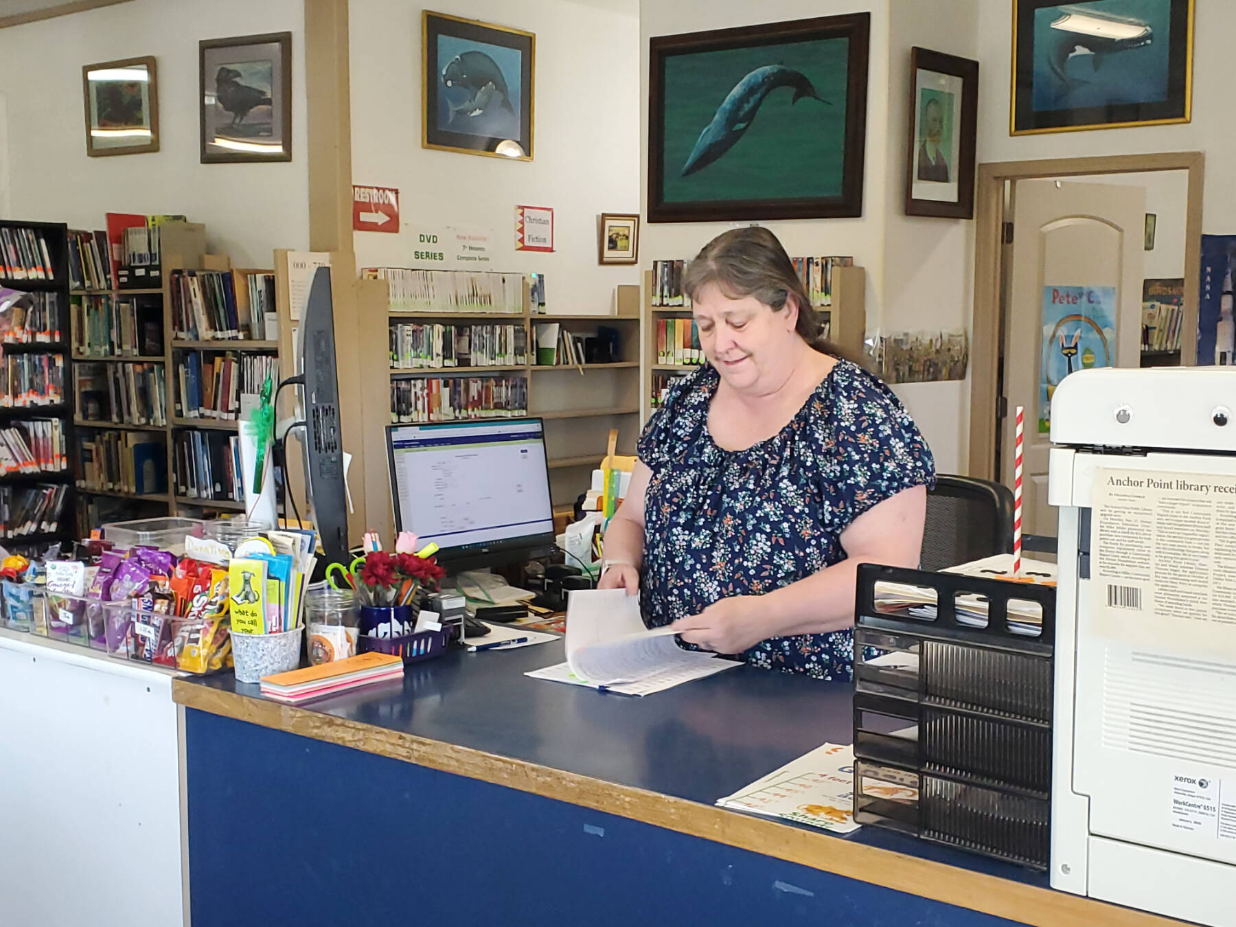Anchor Point Library director Deanna Thomas works the library front counter on Friday, June 6, 2025, in Anchor Point, Alaska. (Delcenia Cosman/Homer News)