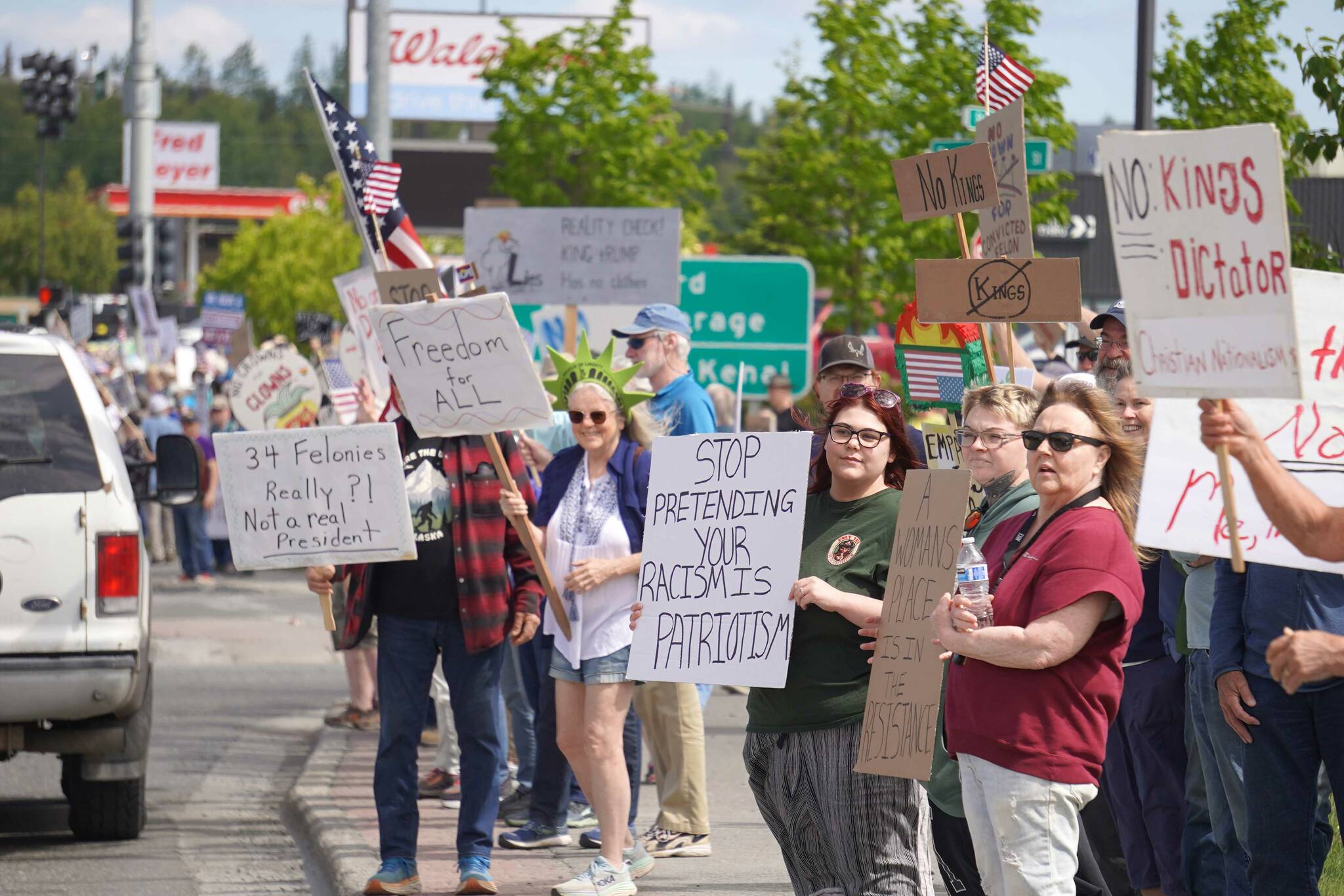 People carrying flags and signs line the Sterling Highway for a “No Kings” protest in Soldotna, Alaska, on Saturday, June 14, 2025. (Jake Dye/Peninsula Clarion)