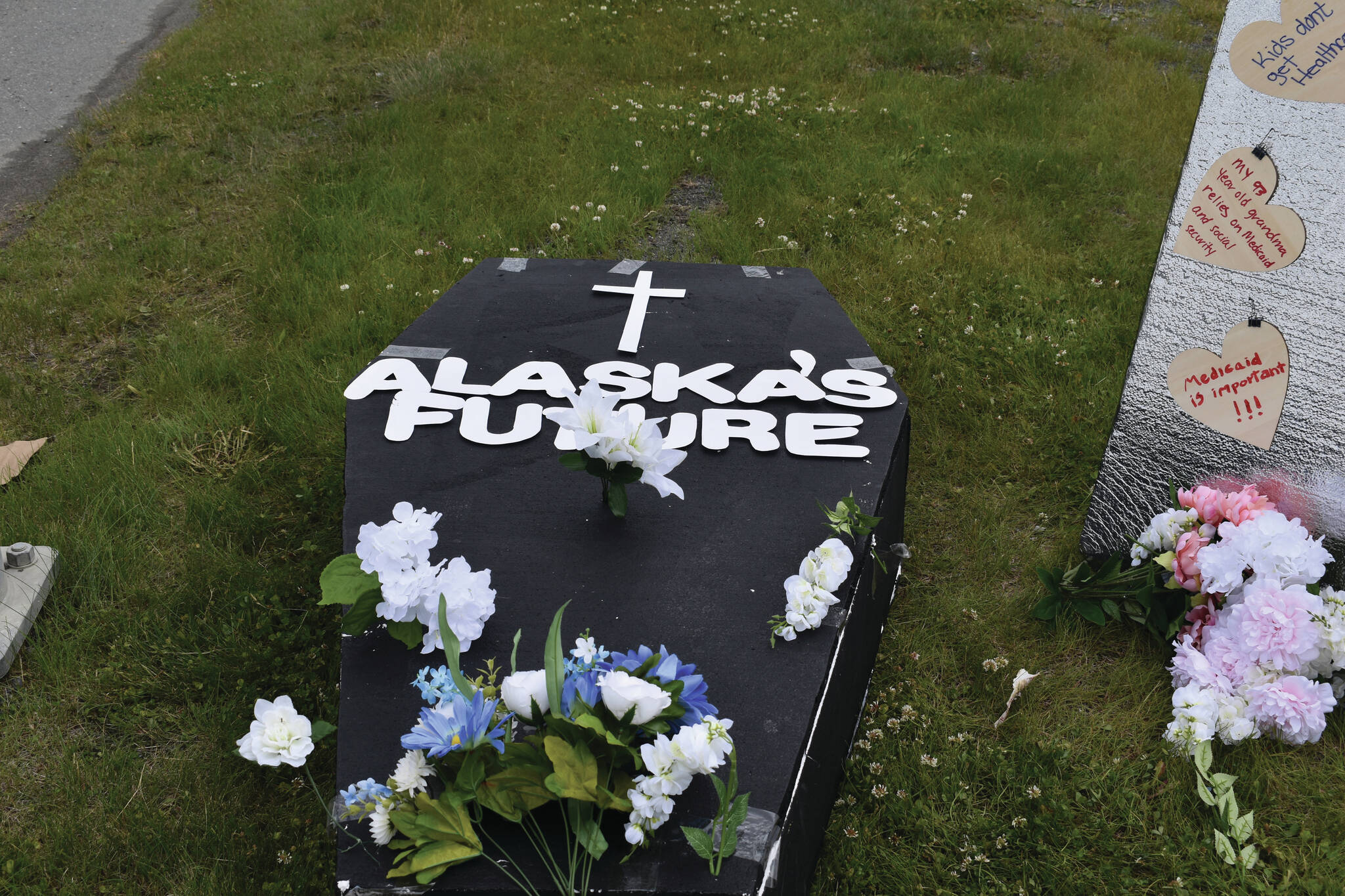 A makeshift coffin decrying the risks of Medicaid funding cuts is seen on Thursday, June 26, in front of the Blazy Mall in Soldotna. The cuts were included in legislation passed by the U.S. Senate early Tuesday morning. (Photo by Jonas Oyoumick/Peninsula Clarion)