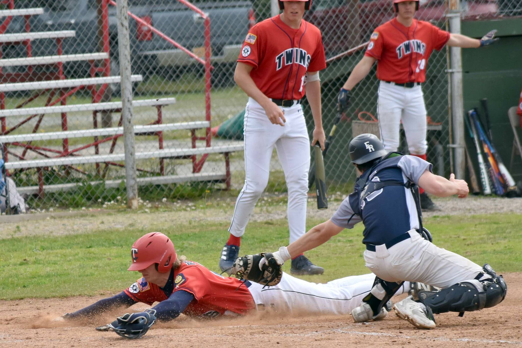 Matthew Schilling of the American Legion Post 20 Twins slides safely past Eagle River catcher Jack Mullen on Monday, July 7, 2025, at Coral Seymour Memorial Park in Kenai, Alaska. (Photo by Jeff Helminiak/Peninsula Clarion)