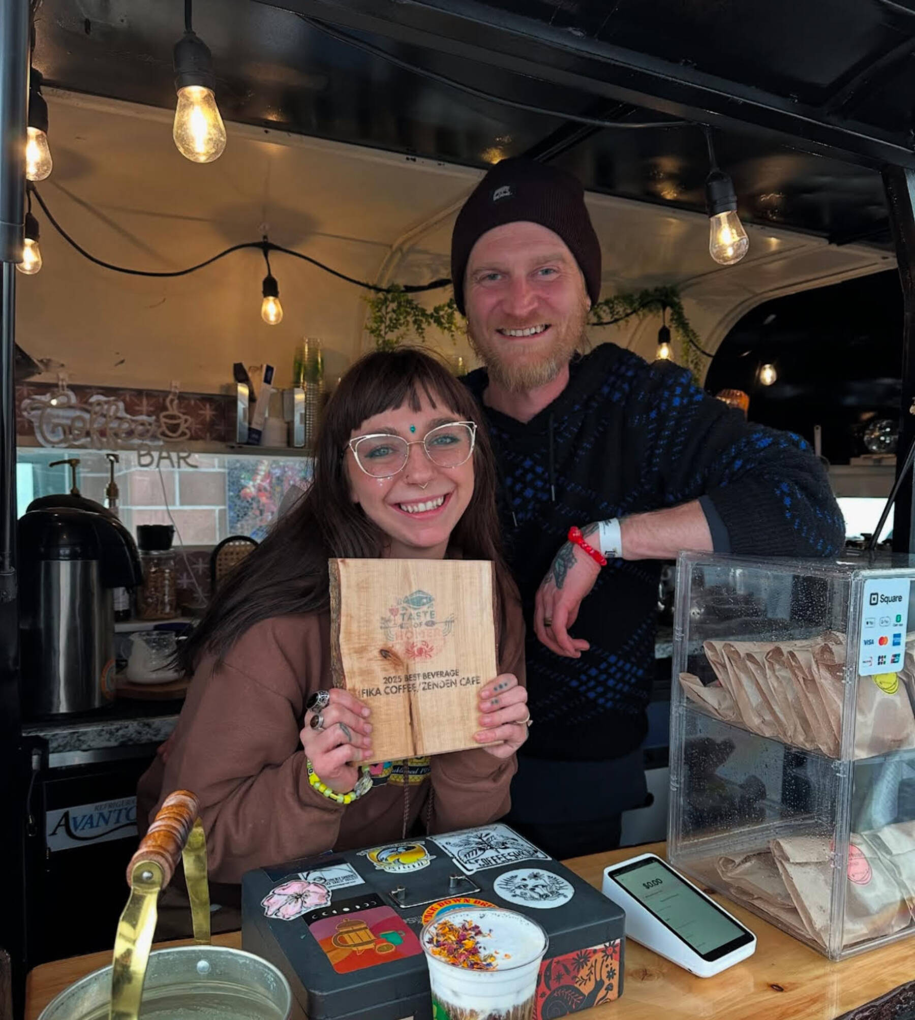 Fika co-owners Sierra Moskios-Schlieman and Tyler Moskios-Schlieman pose for a photograph with their Taste of Homer plaque at the 2025 HarborFest in June. (Photo courtesy of Fika Coffee Roasters)