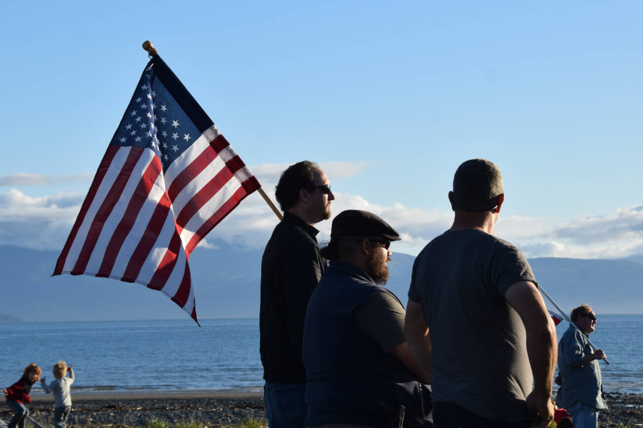 A man holds an American flag at a vigil for Charlie Kirk on Wednesday, Sept. 17, 2025 at Mariner Park on the Homer Spit in Homer, Alaska. (Chloe Pleznac/Homer News)