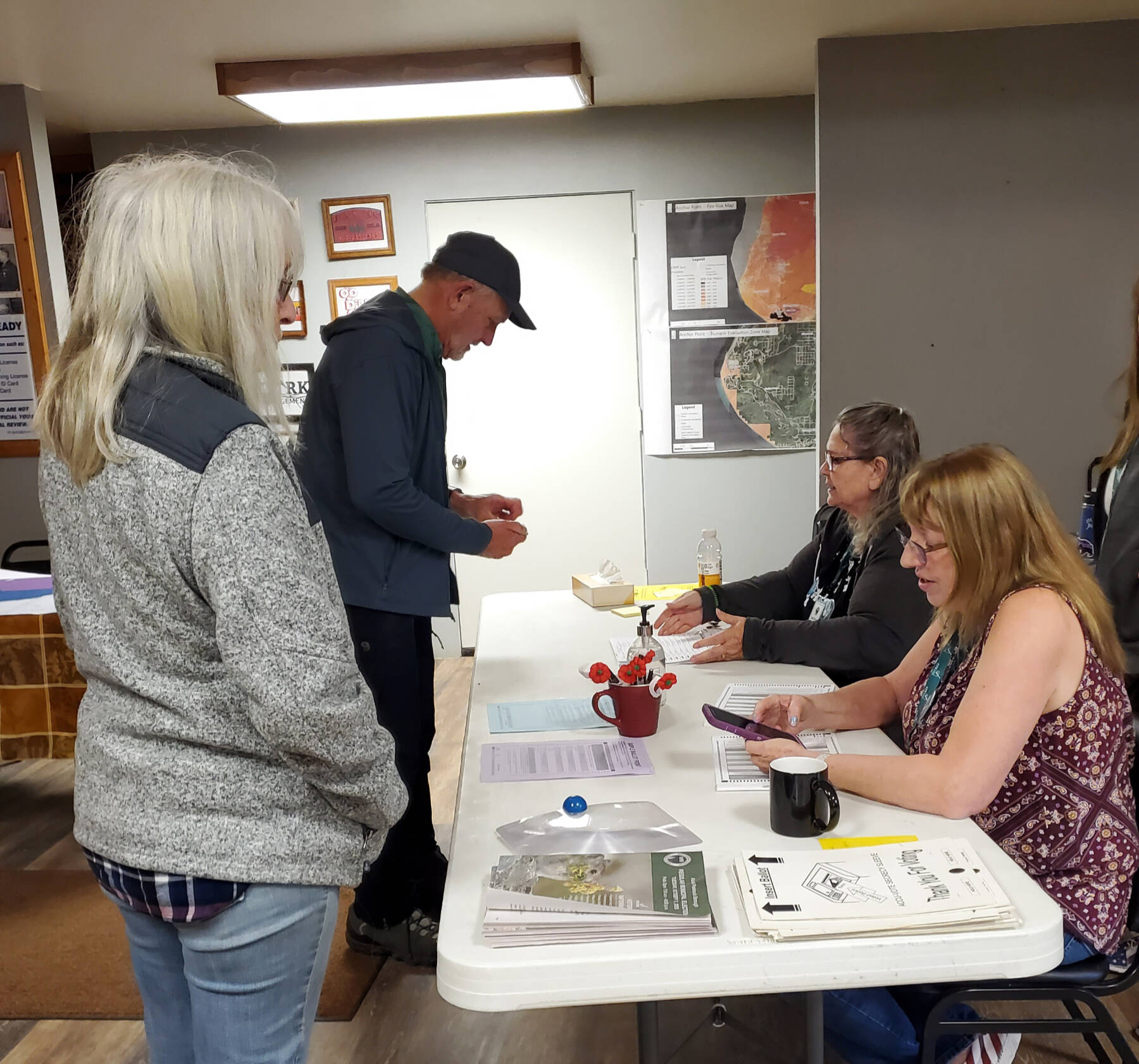 Anchor Point election workers help voters cast their ballots in the Kenai Peninsula Borough election on Tuesday, Oct. 7, 2025, at the Anchor Point Community and Senior Center in Anchor Point, Alaska. (Delcenia Cosman/Homer News)