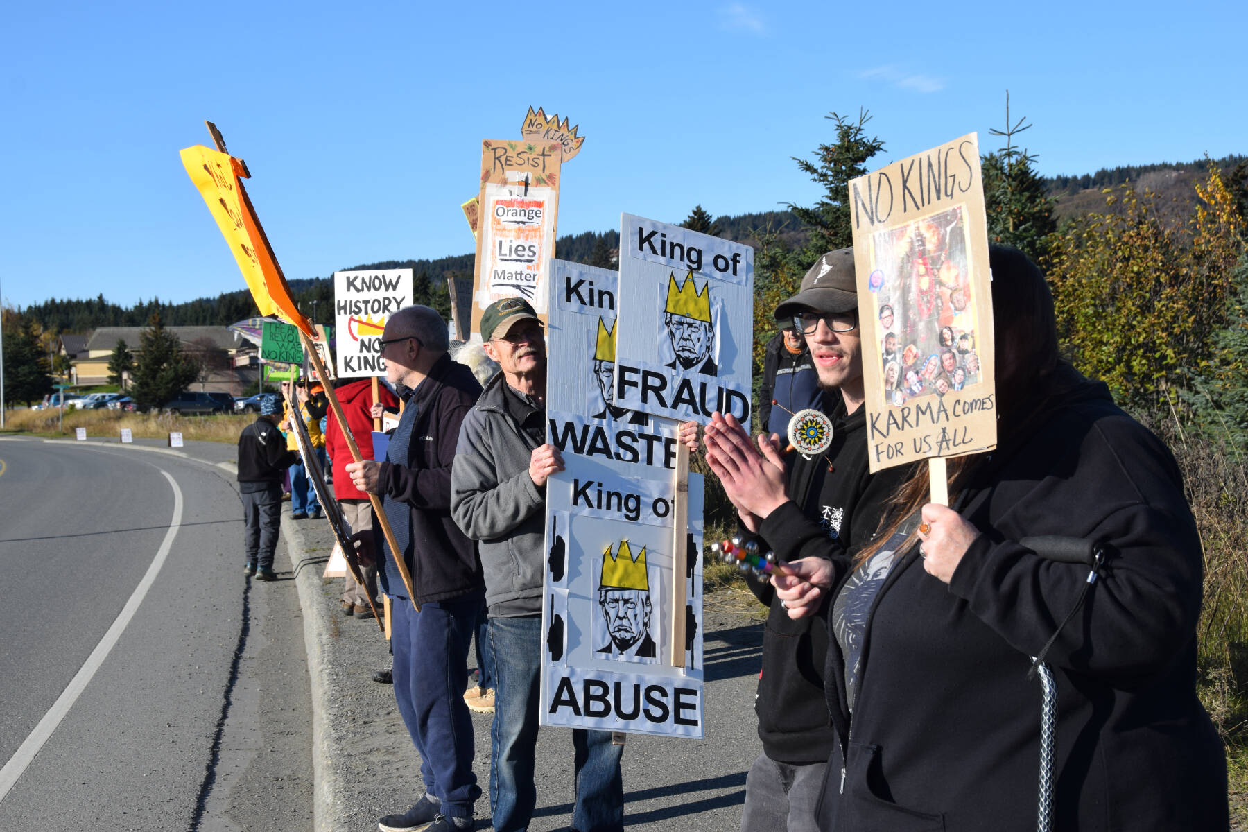 Protesters gather along the Sterling Highway and hold up signs during the “No Kings” demonstration on Saturday, Oct. 18, 2025, in Homer, Alaska. (Delcenia Cosman/Homer News)