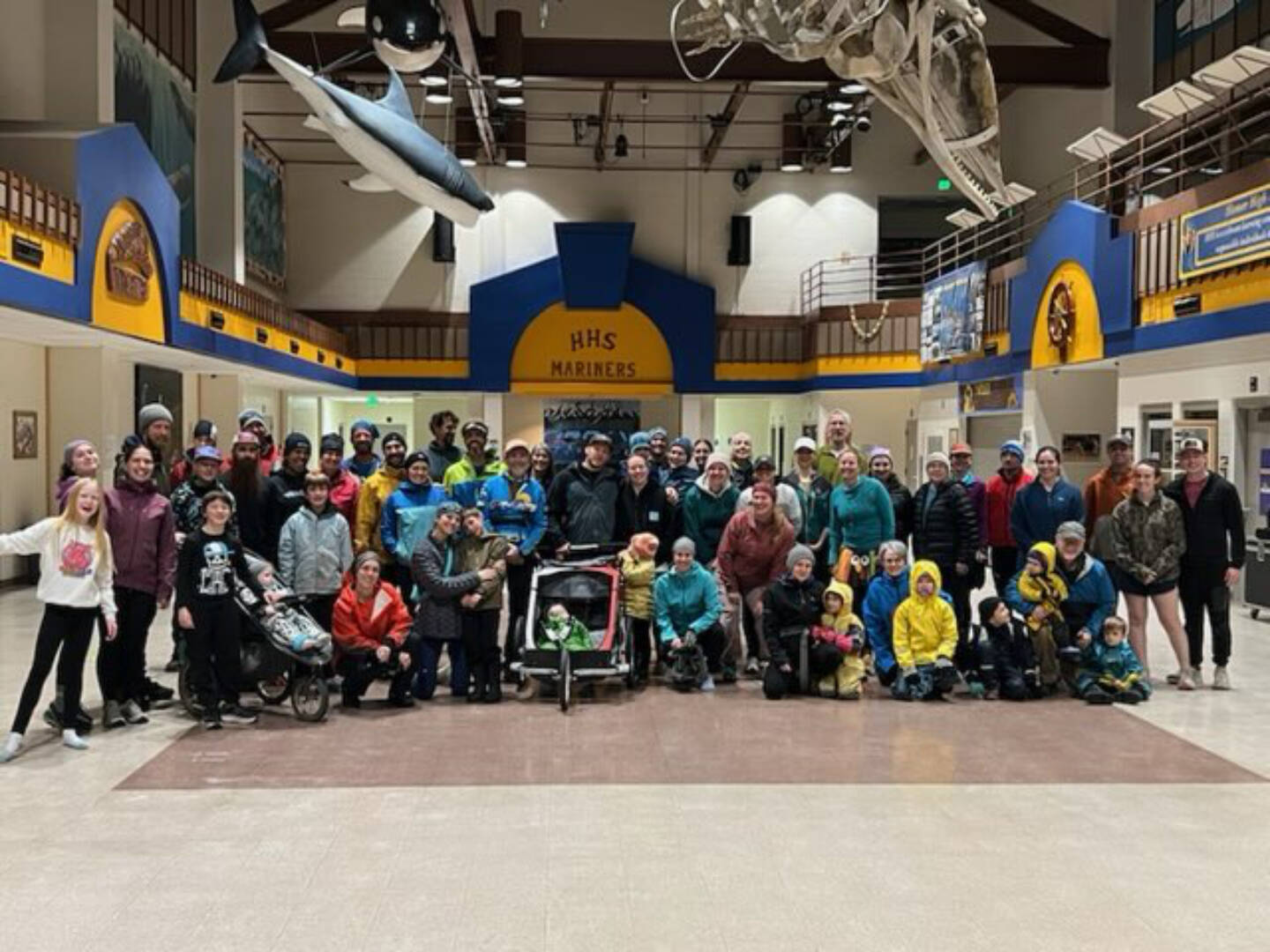 Runners of all ages gather for a photo in the Homer High School Commons after the annual Thanksgiving Turkey Trot on Thursday, Nov. 27, 2025, in Homer, Alaska. Due to icy outdoor conditions, the official run was moved inside to the high school halls. Photo courtesy Matthew Smith