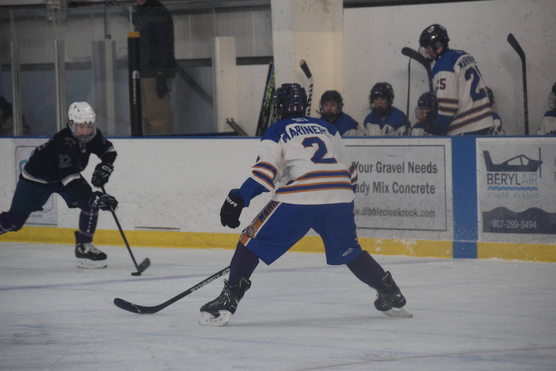 Homer freshman Landon Dehling (2) squares off against a Soldotna player in control of the puck during the Carlin Cup home varsity game on Saturday, Dec. 13, 2025, at the Kevin Bell Arena in Homer, Alaska. (Delcenia Cosman/Homer News)