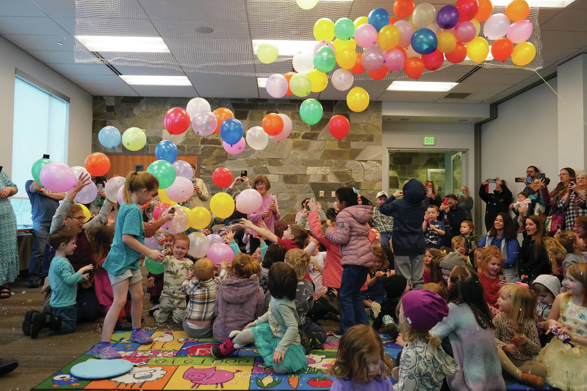 Balloons fall on dozens of children armed with confetti poppers during the Ninth Annual Noon-Years Eve Party at the Soldotna Public Library in Soldotna, Alaska, on New Years Eve, Tuesday, Dec. 31, 2024. (Jake Dye/Peninsula Clarion)