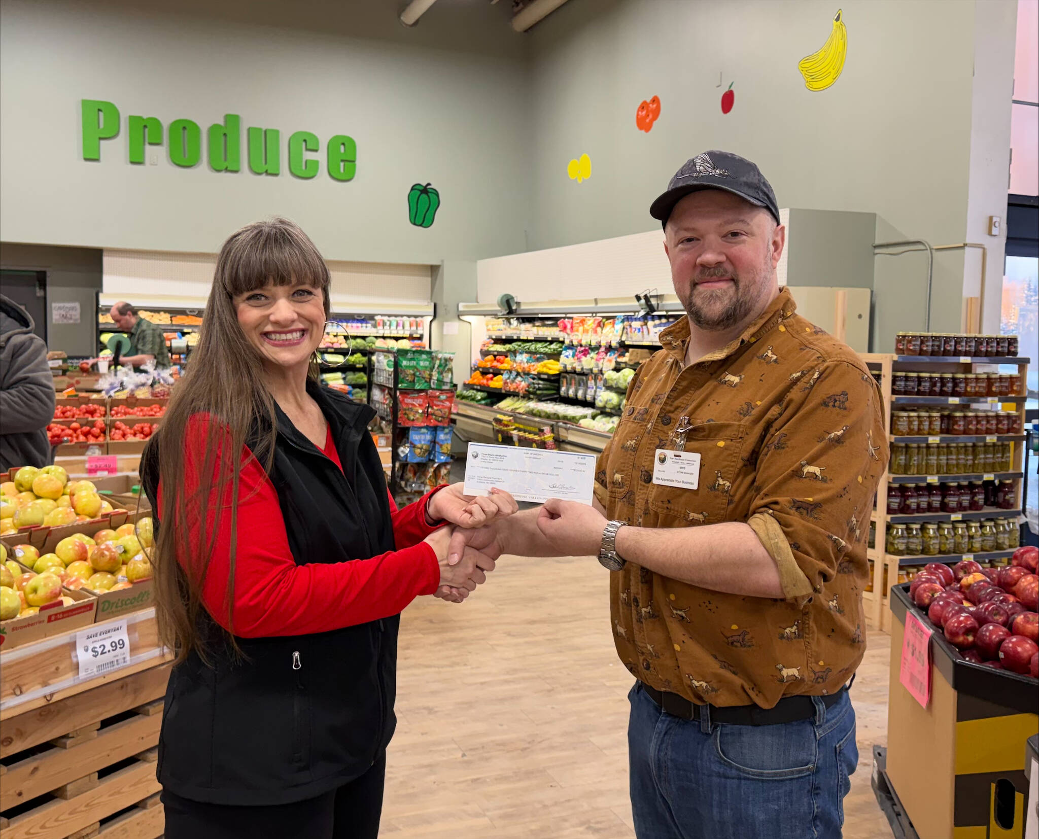 Mike Martin, manager of the Three Bears Alaska location in Soldotna, presents Johna Beech of the Kenai Peninsula Food Bank with a check for $15,432 on Jan. 14, 2026. Photo courtesy of Johna Beech