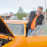 Jim McEwen steps into the classic car he restored at Autozone on Saturday, June 30, 2018 in Soldotna, Alaska. McEwen is a member of the Kaknu Kruzers, a local club composed of members who restore classic cars. The club has a number of events and rives throughou the summe, including the upoming car show at the Soldotna Progress Days parade on July 28. (Photo by Elizabeth Earl/Peninsula Clarion)