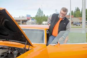 Jim McEwen steps into the classic car he restored at Autozone on Saturday, June 30, 2018 in Soldotna, Alaska. McEwen is a member of the Kaknu Kruzers, a local club composed of members who restore classic cars. The club has a number of events and rives throughou the summe, including the upoming car show at the Soldotna Progress Days parade on July 28. (Photo by Elizabeth Earl/Peninsula Clarion)