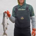Anchorage resident Colton Herman displays a recently caught salmon on Kenai Beach during the opening day of dipnetting season on Tuesday, July 10, 2018, in Kenai, Alaska. Herman has come to Kenai to participate in dipnetting every year since he was a child. Herman said the catch had been slow so far, but would continue fishing until he got his quota. (Photo by Erin Thompson/Peninsula Clarion)