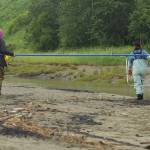 Lorna and Alissa Brotherwood, right, carry a dipnet on Kenai Beach during opening day of dipnetting season on Tuesday, July 10, 2018, in Kenai, Alaska. The family travels from Wasilla annually to participate in the harvest. (Photo by Erin Thompson/Peninsula Clarion)