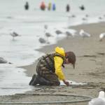 A young boy distracts himself in the Kenai Beach sand on Tuesday, July 10, 2018, during the first day of the dipnetting season. (Photo by Erin Thompson/Peninsula Clarion)