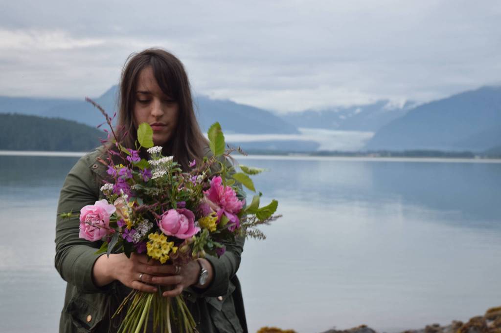 Florist Melissa Garcia Johnson arranges wildflowers at a beach near North Douglas Highway on Wednesday. (Photo by Kevin Gullufsen/Juneau Empire)