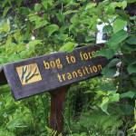 A sign points out to visitors a transition in the climate and makeup of the Pratt Museums botanical garden, pictured here Thursday, July 12, 2018 in Homer, Alaska. One of the projects for Yarrow Hinnant, the museums new gardener, is revamping some of the signage for the garden. (Photo by Megan Pacer/Homer News)