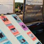 Photos of people who experience disabilities participating in various activities cover a board at the Disability Pride event at Soldotna Creek Park on Saturday, July 21, 2018 in Soldotna, Alaska. (Photo by Elizabeth Earl/Peninsula Clarion)