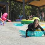 Kids slip and slide down the slip n slide at the Disability Pride event at Soldotna Creek Park on Saturday, July 21, 2018 in Soldotna, Alaska. (Photo by Elizabeth Earl/Peninsula Clarion)