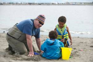 Dipnetter Brad Gamblin (left) digs in the sand of Kenais north beach with his grandchildren Stella (in blue) and Marly Wilson on Thursday, July 26, 2018 in Kenai, Alaska. The three, plus grandmother Cher Gamblin, brought the grandchildren on their first dipnetting trip this year. The morning, Brad Gamblin said, was very productive. Getting up early, he said the family had caught a dozen salmon by 9 a.m. (Ben Boettger/Peninsula Clarion)