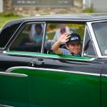 A participant in classic car club Kaknu Kruzers display in the Progress Days parade waves to spectators on Saturday, July 28, 2018 in Soldotna, Alaska. The parade kicks off the weekend-long event celebrating Soldotnas history, with a market on Saturday and Sunday in Soldotna Creek Park and a concert Saturday night followed by a free community barbecue Sunday. (Photo by Elizabeth Earl/Peninsula Clarion)